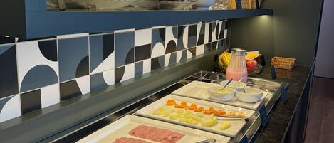 A buffet with various food items and utensils.