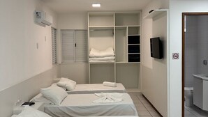 Ένα δωμάτιο ξενοδοχείου με δύο κρεβάτια, μια ντουλάπα, μια τηλεόραση και ένα μπάνιο.
