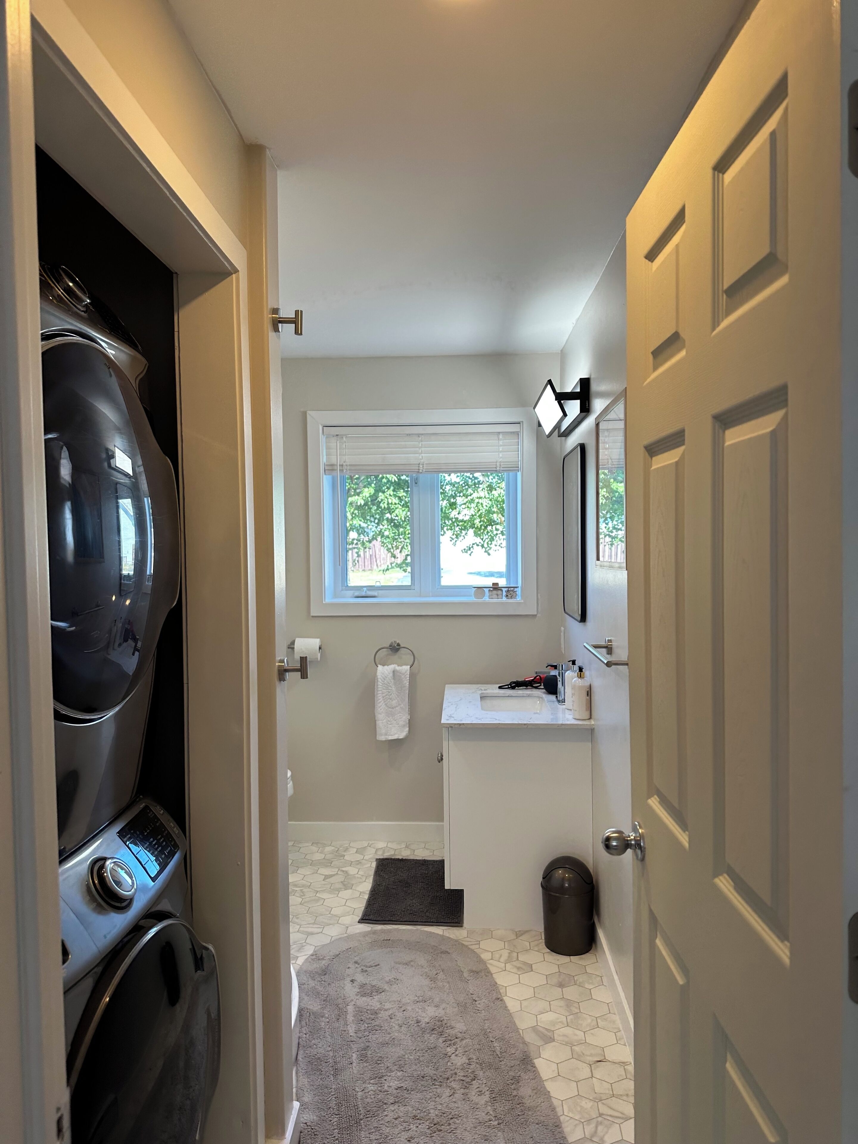 A compact bathroom with a toilet, sink, and window.