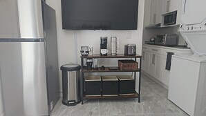 Een moderne keuken met een roestvrijstalen koelkast, een koffieapparaat, een broodrooster en een magnetron op het aanrecht.