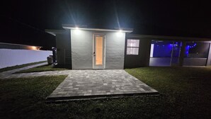 Een modern huis met een geplaveid voetpad, een deur en een klein portaal.