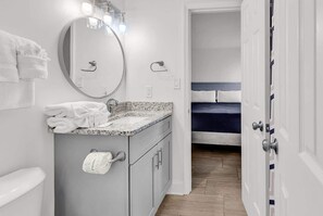 A bathroom with a sink, mirror, and towel rack. - Direct Oceanfront w/ Private Balcony (North Myrtle Beach)