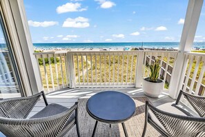 A balcony with wicker chairs, a small table, and a potted plant. - Direct Oceanfront w/ Private Balcony (North Myrtle Beach)