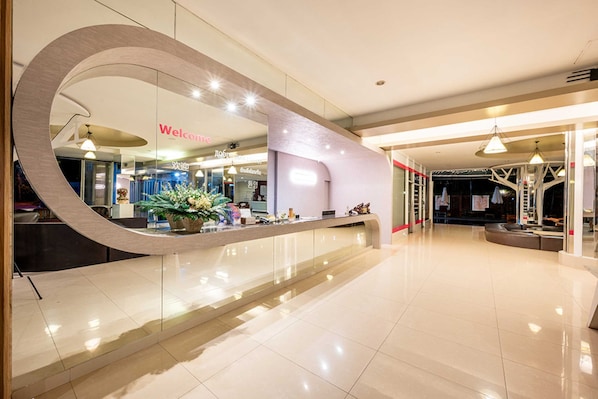 A modern hotel lobby with a curved reception desk, a 'Welcome' sign, and a glass partition. - Sunday JA Plus Hotel (Pattaya)