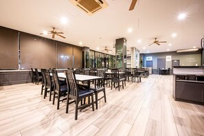 A spacious dining area with multiple tables and chairs, ceiling fans, and a coffee station. - Sunday JA Plus Hotel (Pattaya)