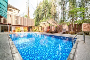 A swimming pool with tiled blue water, surrounded by a wooden deck and lounge chairs. - Sunday JA Plus Hotel (Pattaya)