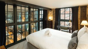 Een hotelkamer met een groot bed, een bureau en uitzicht.