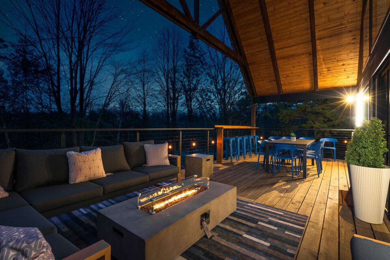 An outdoor deck with a sofa, fire feature, and dining area.