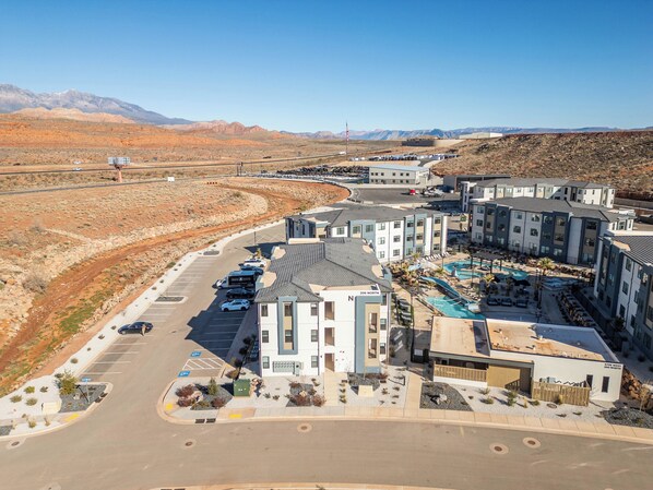 A modern hotel with multiple buildings, a parking lot, and a swimming pool area. - The Jungle Retreat • Zion Getaway • Water Park Fun (Hurricane)