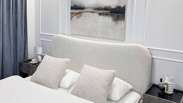 A modern bedroom with a large bed, a nightstand with a lamp, and a painting on the wall. - Cozy 1-bedroom studio in amazing Katowice, 24h check-in (Katowice)