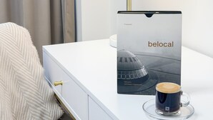 A white bedside table with a lamp, a book titled 'belocal', and a cup of coffee. - Cozy 1-bedroom studio in amazing Katowice, 24h check-in (Katowice)