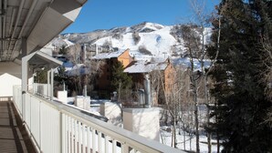 Un hôtel doté d’un balcon donnant sur un paysage montagneux enneigé.