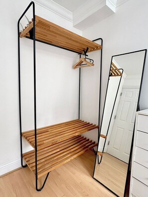 Ein Zimmer mit einer Holzhockerreih, einem Spiegel und einer weißen Tür.