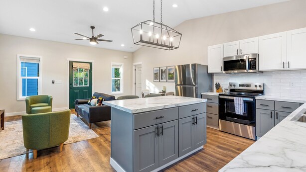 A modern kitchen with grey cabinets, a marble countertop, and stainless steel appliances. - The Evergreen Escape - Spacious 1 bed Unit (Kennewick)