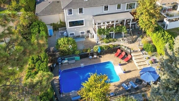 A two-story house with a swimming pool, a covered patio, and a well-maintained garden. - The Susie Pearl Bed & Breakfast (Kelowna)