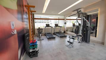 A modern gym with treadmills, exercise balls, and weight machines.