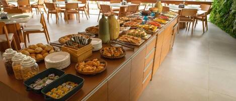 A buffet setup with various food items and utensils.