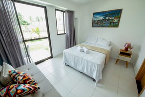 A hotel room with a bed, a sofa, a nightstand, and a painting on the wall. - Mana Beach Experience By Aft (Ipojuca)