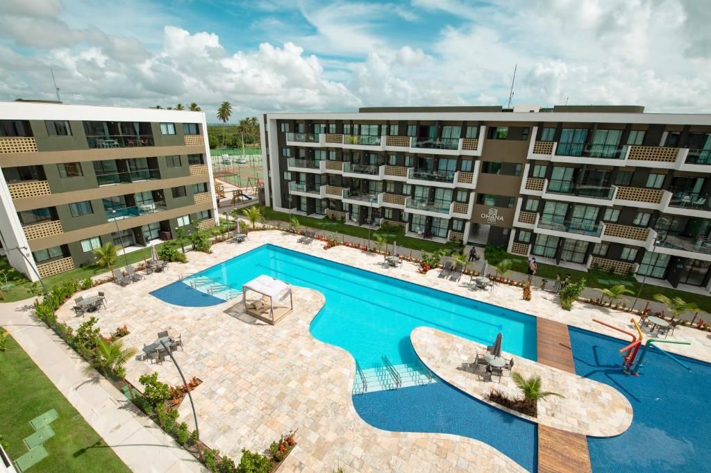 Un hôtel moderne doté d’une grande piscine, de nombreux balcons et d’un espace extérieur bien aménagé.