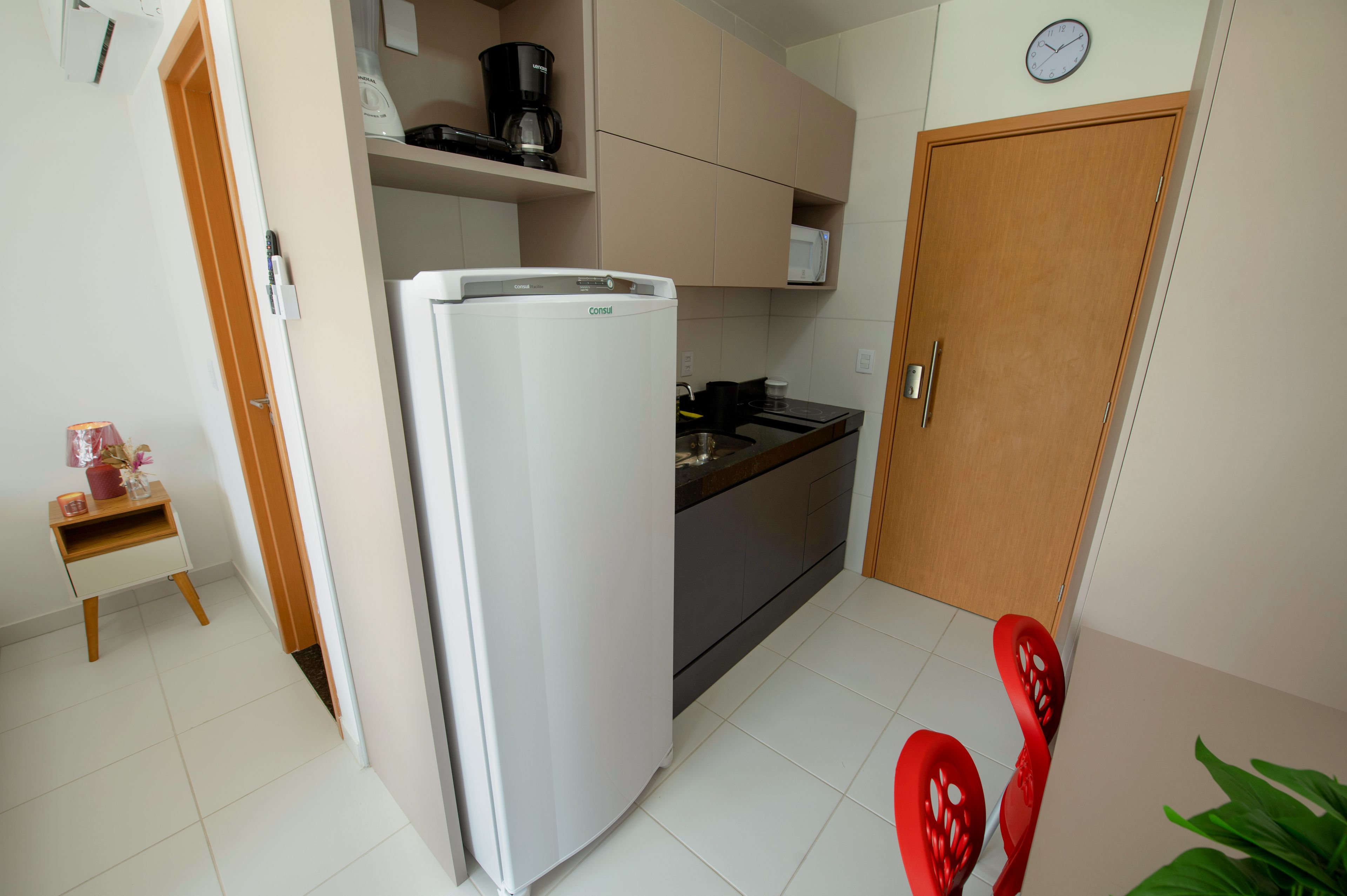 A compact kitchen with a refrigerator, microwave, and coffee maker on the countertop.