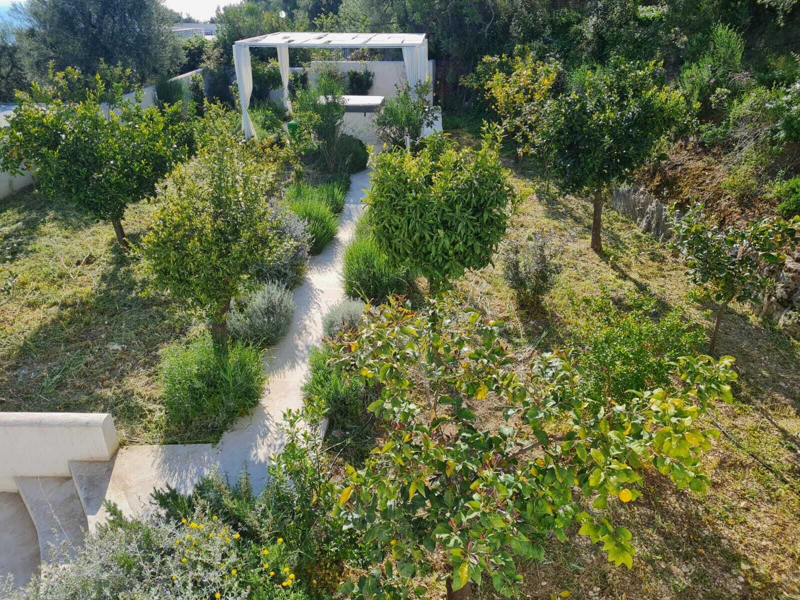 Un jardín con un sendero que lleva a una estructura blanca.