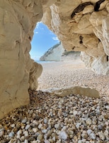 Una playa cerca, arena negra, sillas reclinables de playa, sombrillas
