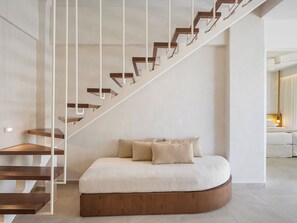 A modern interior with a staircase, a curved bed, and a minimalist design. - Vergina Beach Resort (Chania)