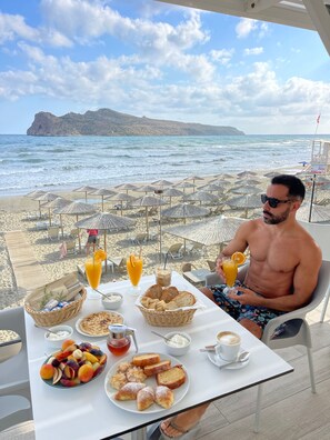 A man dining at a table with a view of the beach and ocean. - Vergina Beach Resort (Chania)