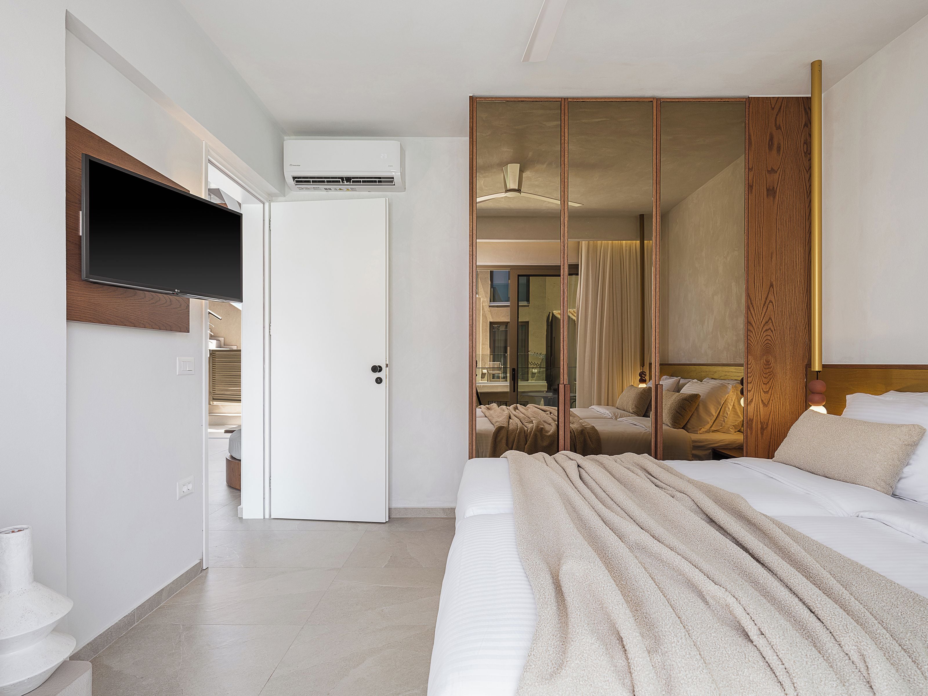 Una habitación de hotel moderna con cama, televisión, armario y aire acondicionado.