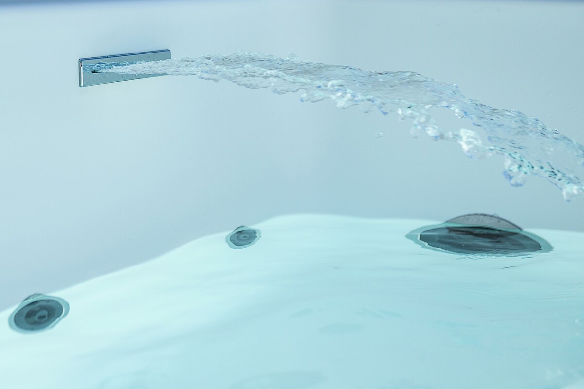A close-up of a water spout with water flowing from it.