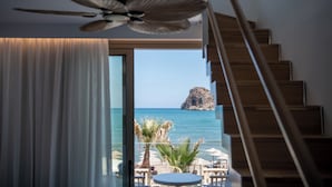 A room with a ceiling fan, a staircase, and a view of the sea. - Vergina Beach Resort (Chania)