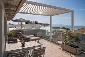 A rooftop terrace with outdoor seating, a pergola, and a view of the sea. - Vergina Beach Resort (Chania)
