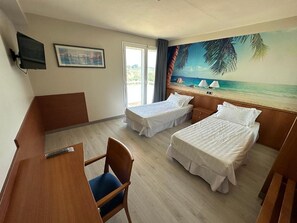 A hotel room with two beds, a desk, a chair, a TV, and a beach mural on the wall. - Futurotel Cambrils Paradise Resort (Vinyols i els Arcs)