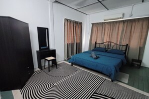 A bedroom with a bed, a desk, a chair, and a wardrobe.