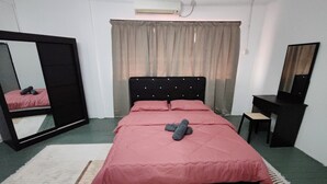 A bedroom with a bed, a mirror, a desk, and a window with curtains. - DRH Villa (Ipoh)