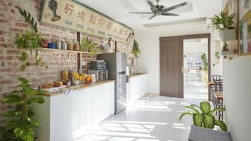 A modern kitchen with a brick wall, a ceiling fan, and a sign above the counter.