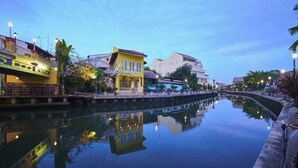 A canal with buildings reflecting on the water, a bridge, and street lamps. - Sleepy Nomad Hostel (Malacca City)
