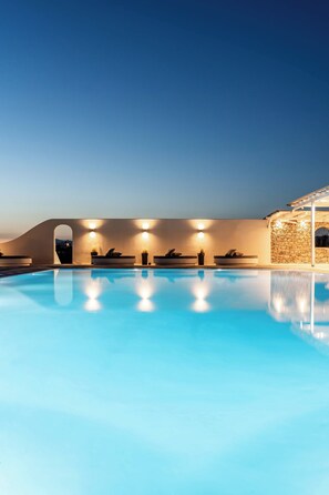 A swimming pool with lounge chairs and wall-mounted lights. - Philosophy Of Mykonos (Mykonos)