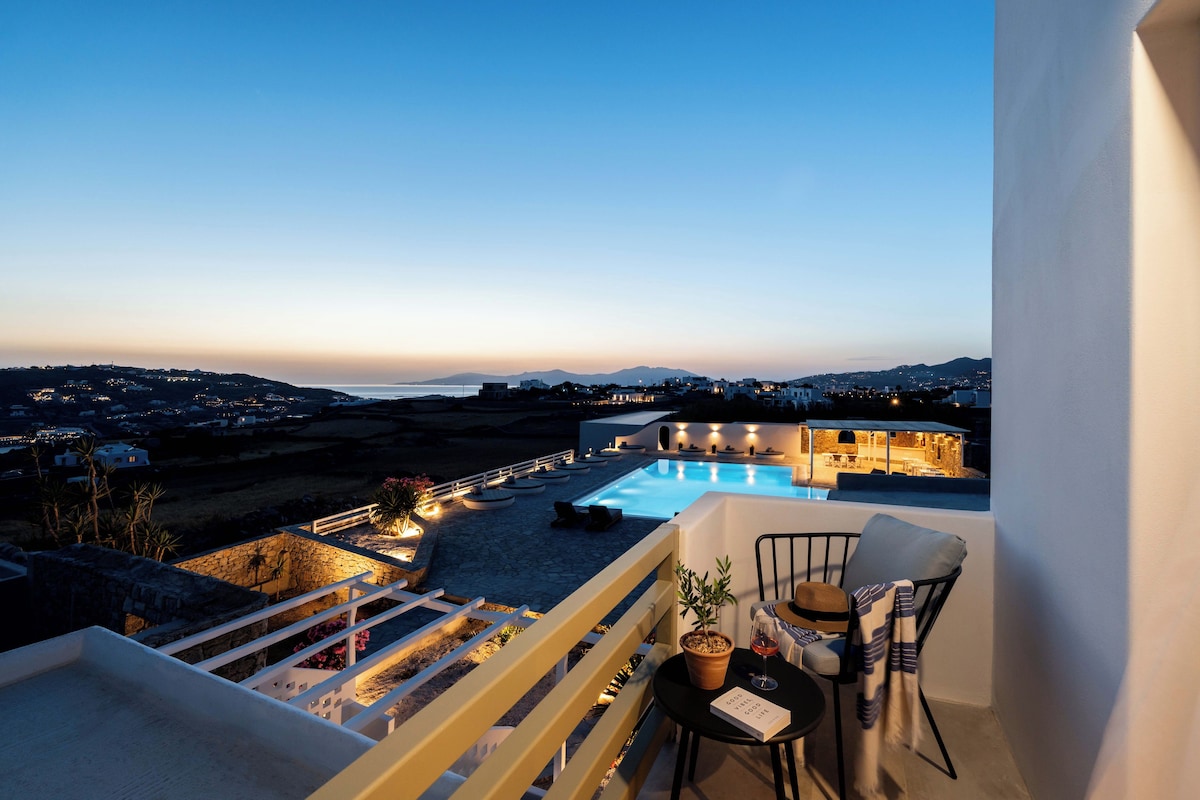 A balcony with a view of a pool and distant landscape.