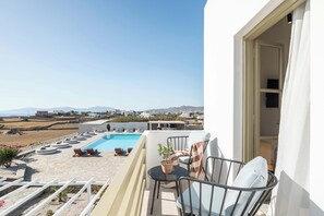 A balcony with a pool, outdoor seating, and a view of the landscape. - Philosophy Of Mykonos (Mykonos)