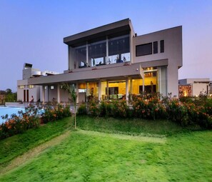 A modern two-story house with a swimming pool, surrounded by well-maintained gardens and a clear sky. - Araiya Gir,a Mavintara Resort (Talala)