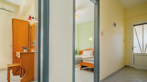 A hotel room with a wooden desk, a bed, and a bathroom with a toilet and sink. - Solena Studios Kavos (Corfu)