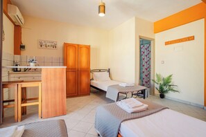 A hotel room with two beds, a desk, a wardrobe, and a shower area. - Solena Studios Kavos (Corfu)