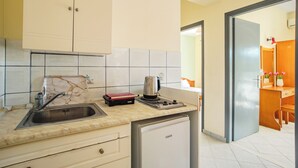 A kitchen with a sink, a coffee maker, a toaster, and a refrigerator. - Solena Studios Kavos (Corfu)
