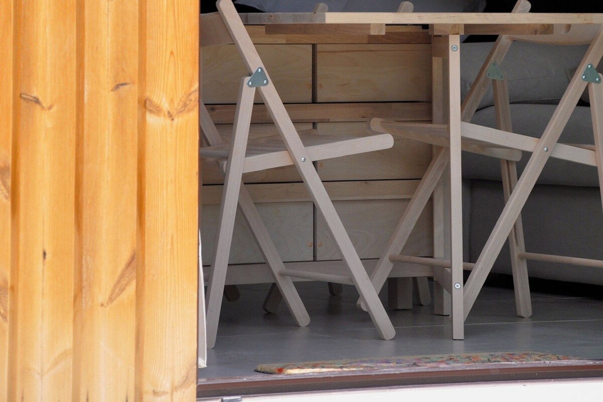 Una habitación con cama, una mesa de madera y una silla.