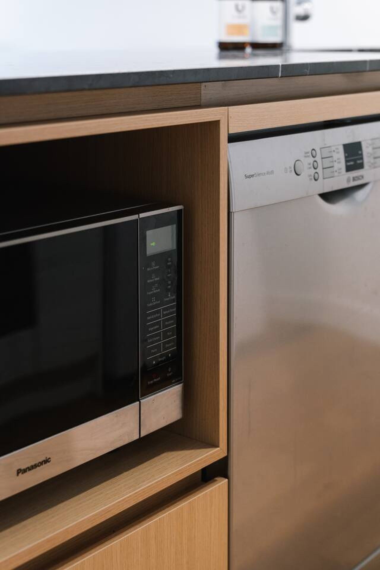A kitchen with a built-in microwave and dishwasher.