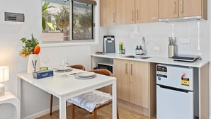 Une cuisine moderne avec des meubles en bois, un lave-vaisselle intégré et une fenêtre donnant sur un espace verdoyant.