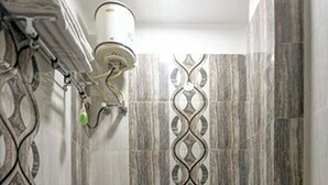 A bathroom with a toilet, a sink, and a shower area. - Hotel Lookout Stay (New Delhi)