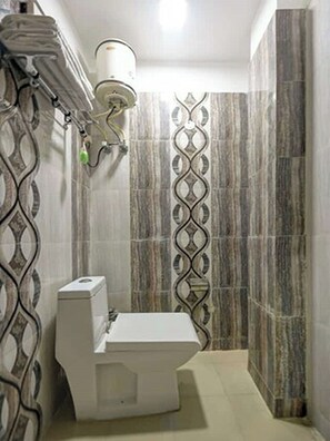 A bathroom with a toilet, a sink, and a shower area. - Hotel Lookout Stay (New Delhi)
