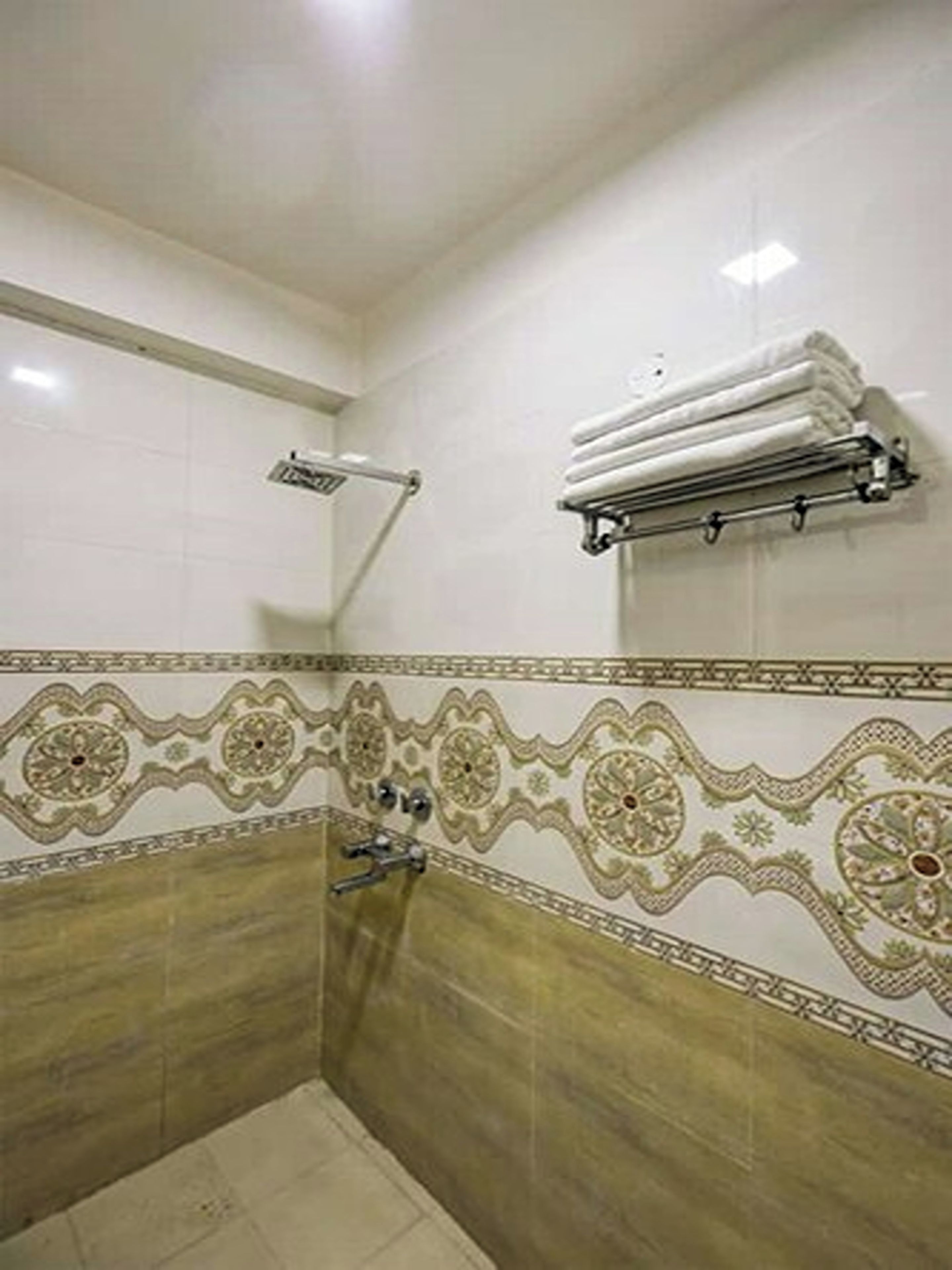 A bathroom with a shower, tiled walls, and a towel rack.